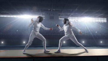 Fencing competitive duel. Female fencer fight on big professional stage. They are wearing an unbranded fencing suit.